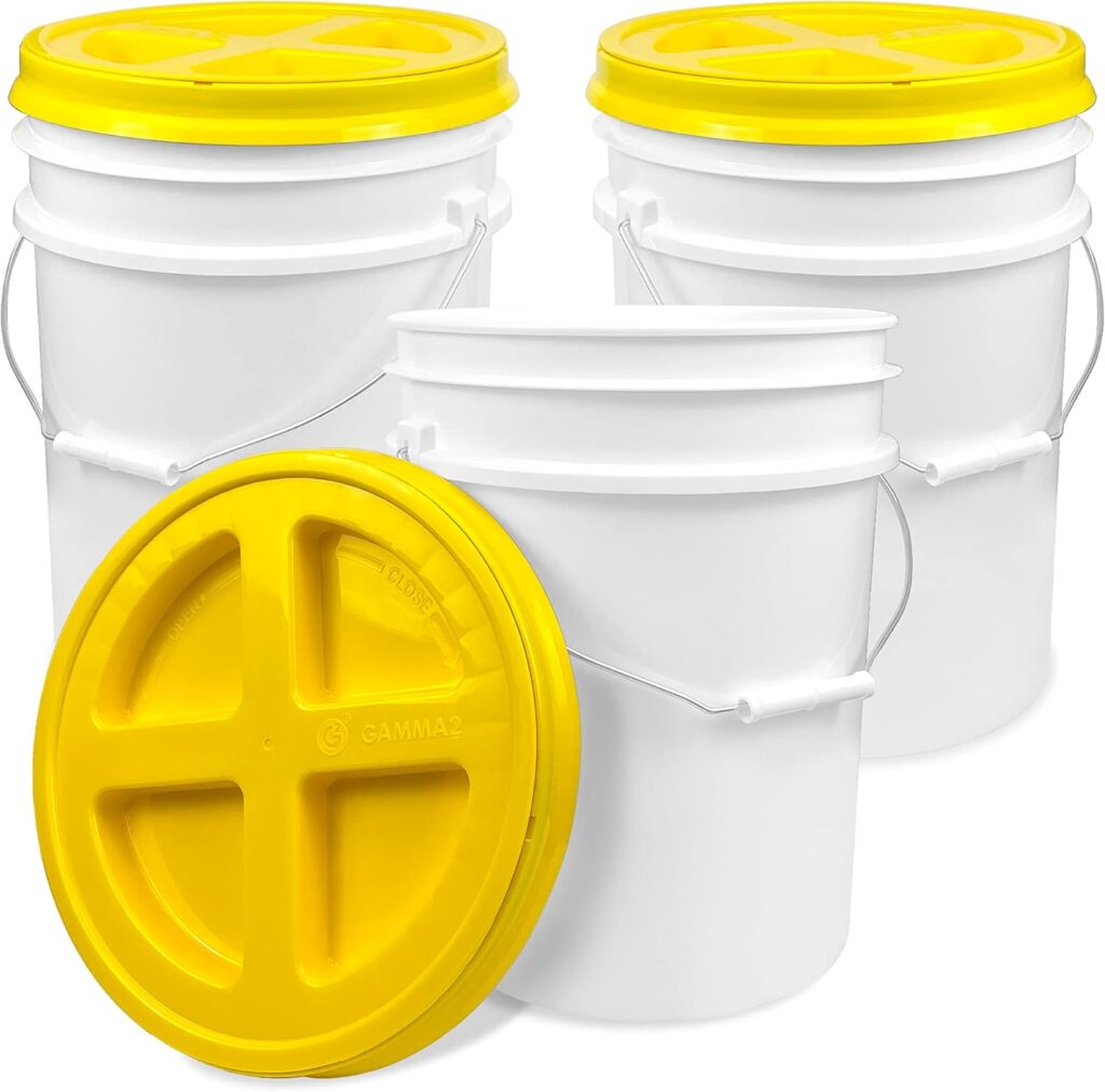 This image is of 3 white buckets with yellow lids. The lids screw off and one lid is sitting in front of the bucket.