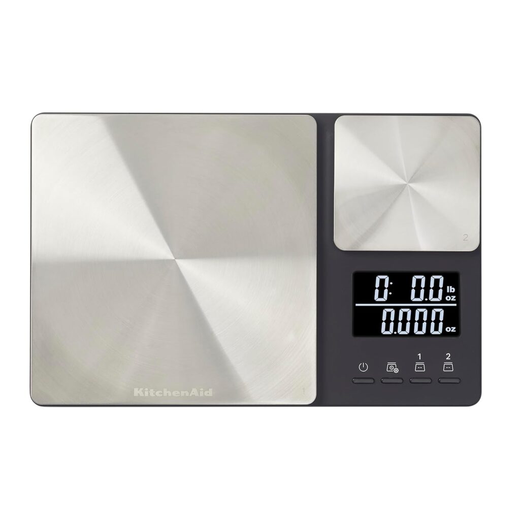 This image is of a rectangular scale for baking. There is a large silver square on the left side for large items and a smaller square on the right for weighing smaller amounts. There is a black screen with white numbers for the output. Shopping Bailey Basic's pantry, you have to have one of these.