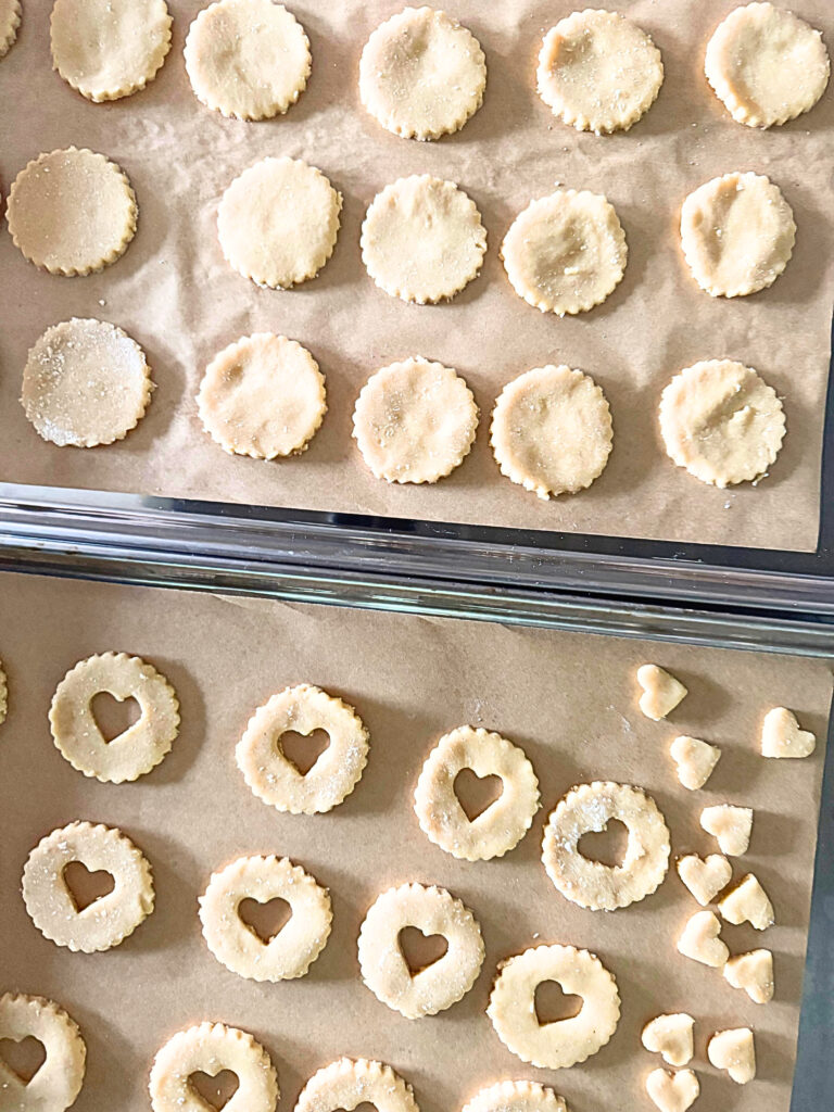 Linzer cookies on a tray with a tray of  linzer cookies
