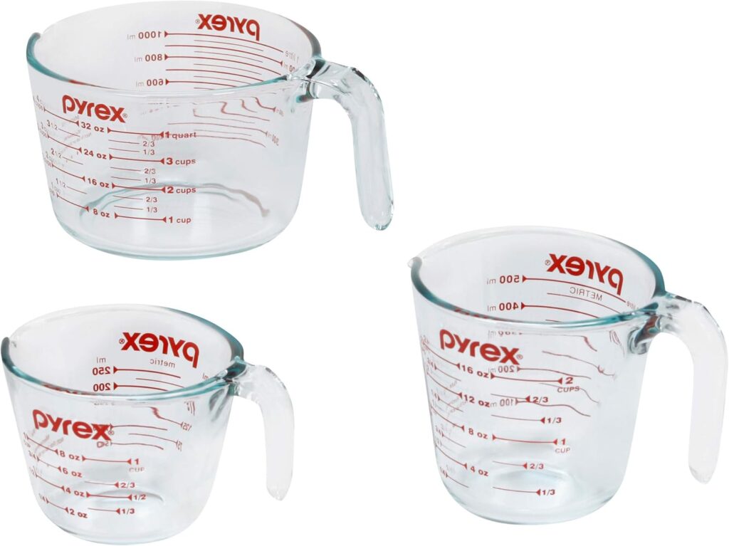 This image is of 3 glass, handled measuring cups with red text "pyrex" across the top and measurements on the front and back sides. Bailey Basic's Kitchen uses these daily.