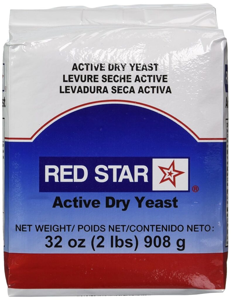 This image is of a bag of yeast. The packaging is white on the top, blue in the middle and red on the bottom. It says, "Red Star" in the center and "active dry yeast" below.