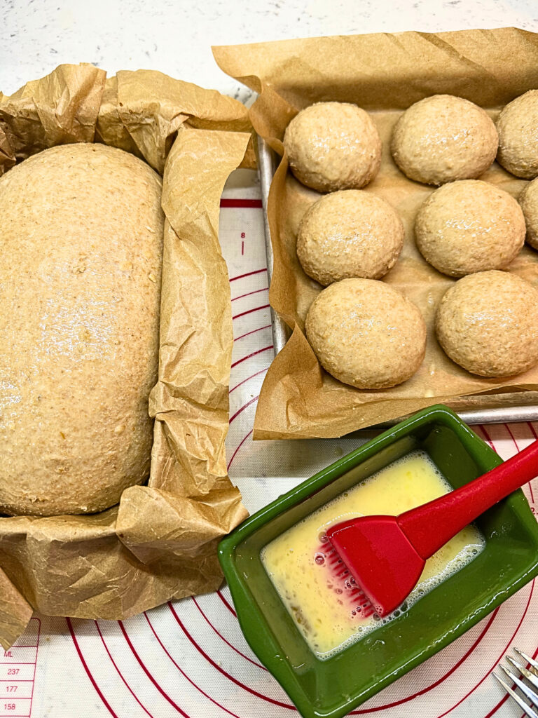 Loaf of honey oat wheat bread and dinner rolls