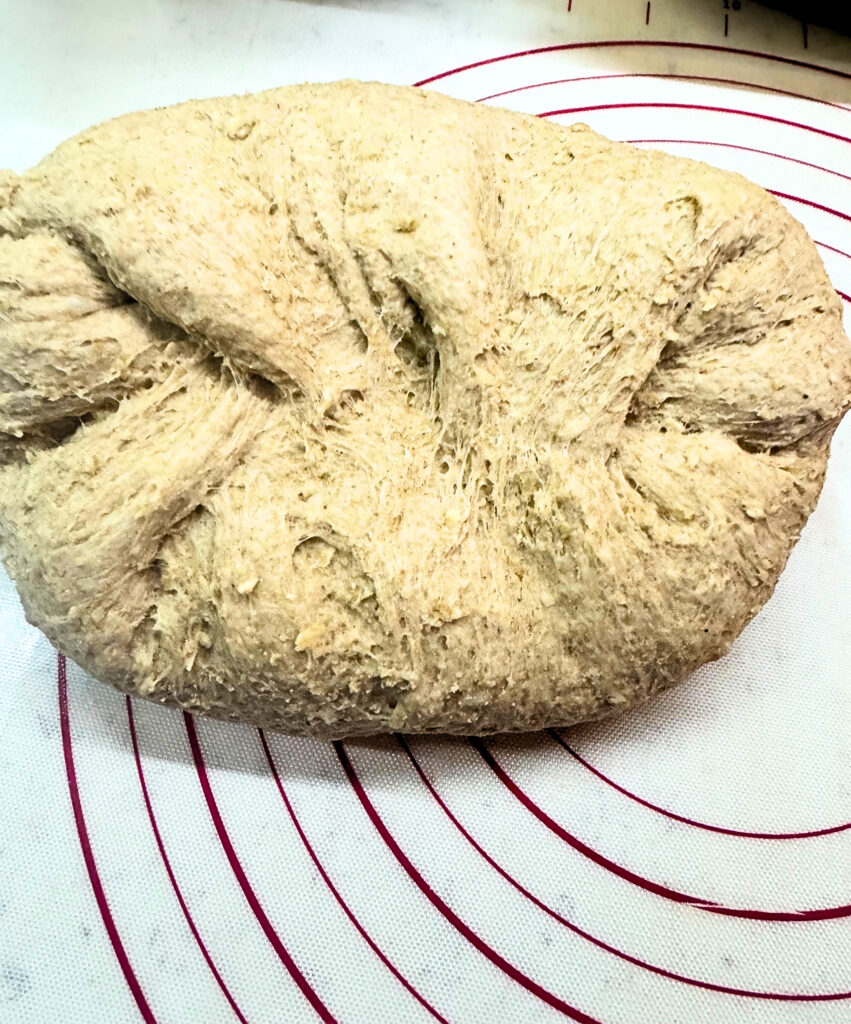 Honey oat wheat bread dough rolled out for a loaf pan