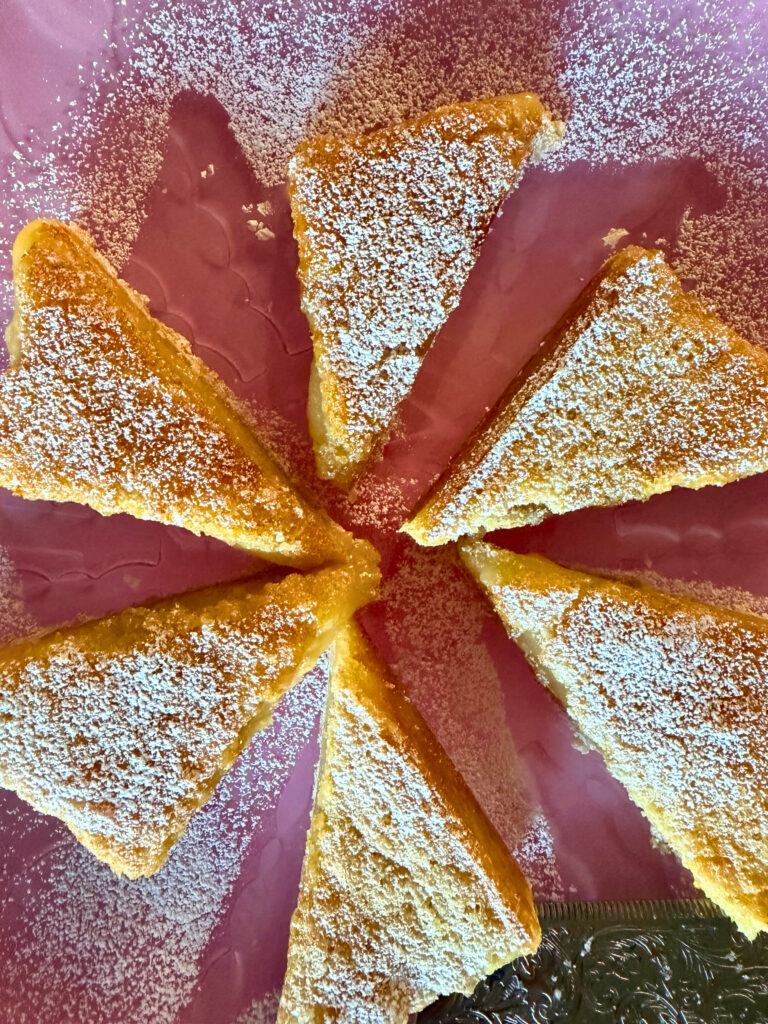 Lemon bars cut on a pink platter