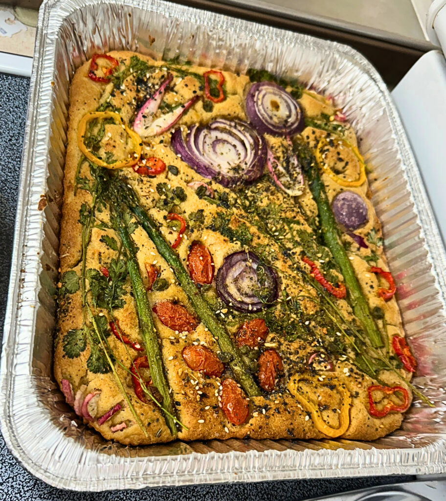 Focaccia bread topped with sliced veggies to look like art