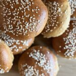 Fresh Milled Hamburger buns piled on a cutting board