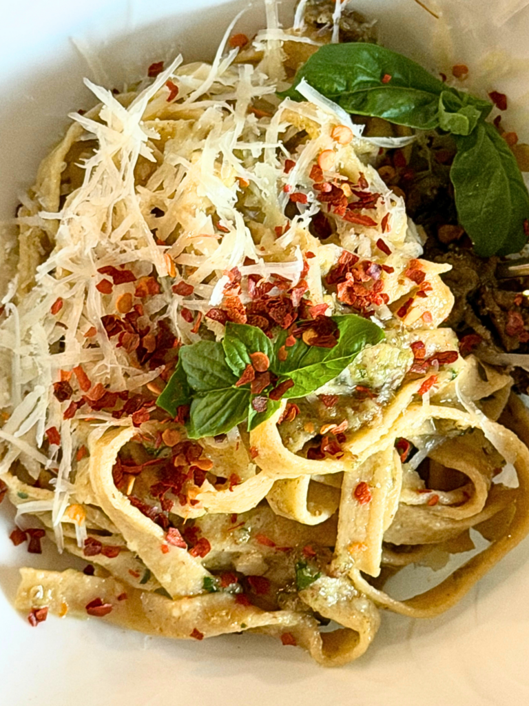 pasta made with fresh milled flour in a bowl with cheese and red pepper flakes